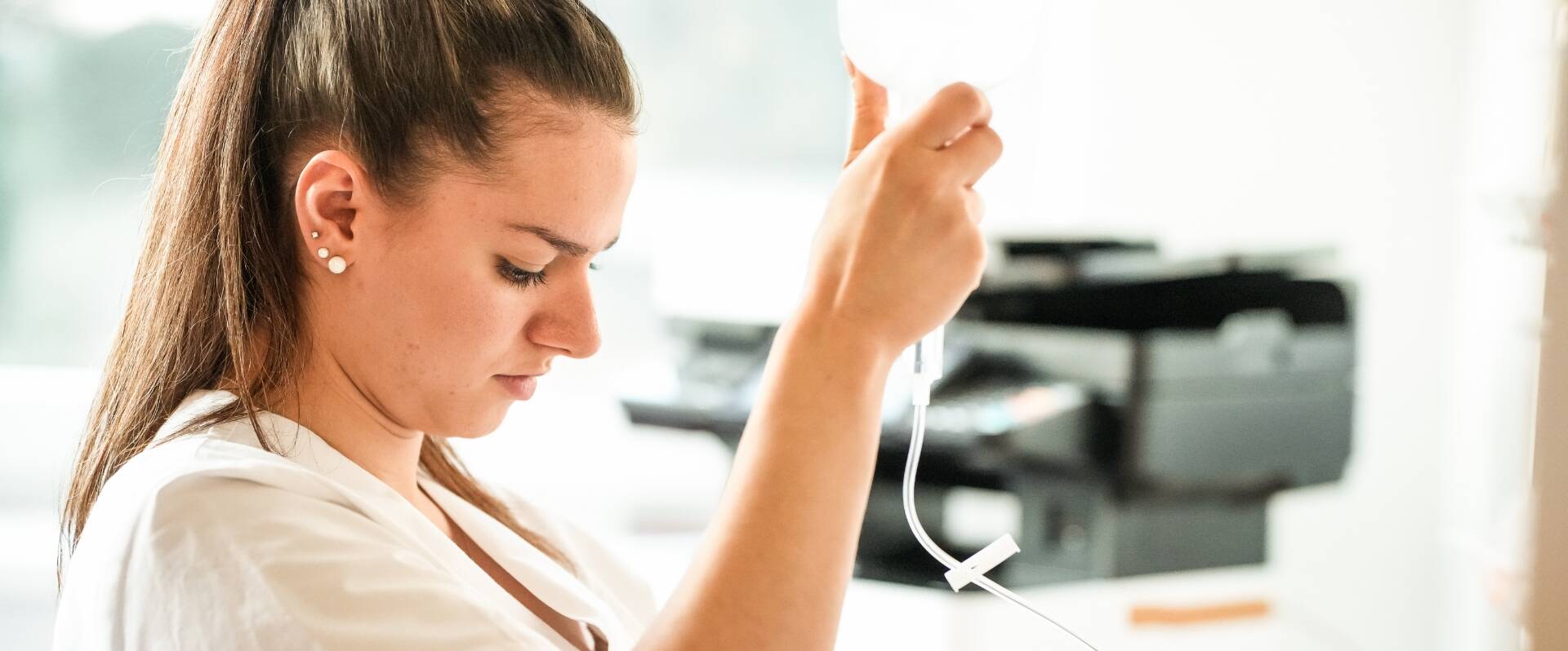 Junge Pflegerin stellt eine Infusion bereit